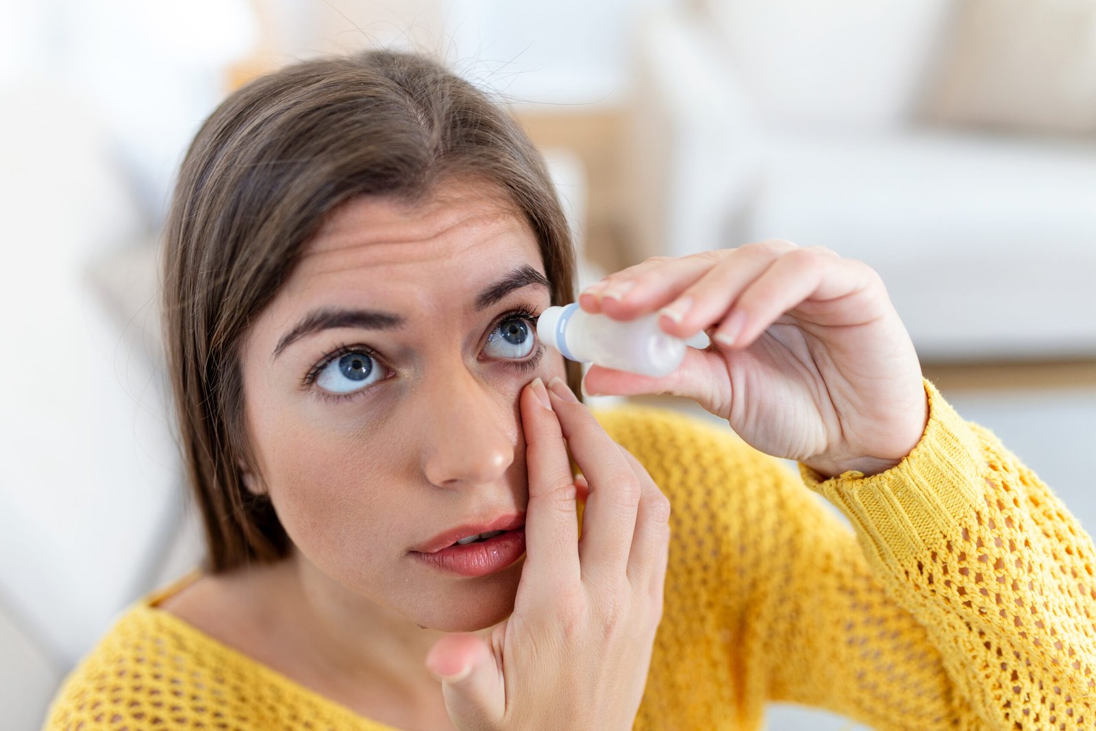 Woman using lubricating eye drops for dry eyes