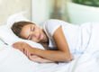 Woman sleeping on her side with her cheek pressed into a white pillow