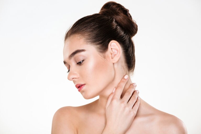 Chemical Peel for Neck Discoloration in Chicago Woman touching the smooth, even toned skin of her neck after a chemical peel for neck discoloration