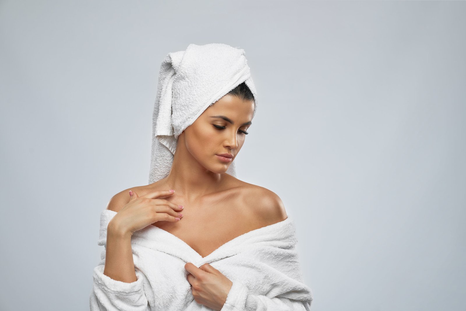 Dark Spots on Chest Treatment in Chicago Woman in a robe checking the skin on her chest and shoulder before dark spots on chest treatment