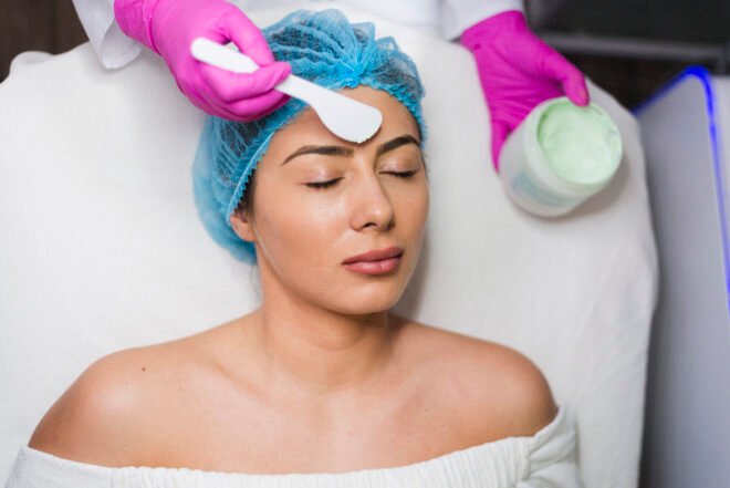 Dermaplaning vs Facial Waxing in Chicago Aesthetician applying a soothing mask to a relaxed client during a facial