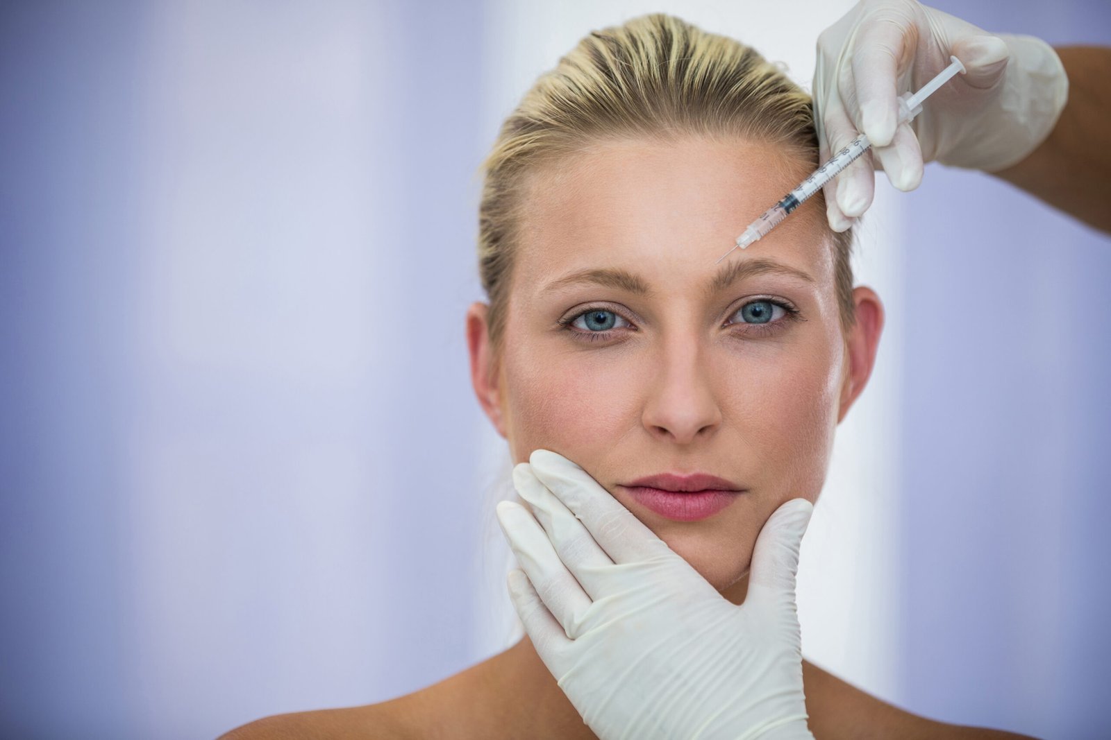 Dysport Frown Line Injection Photo Woman receiving a neuromodulator injection between the brows for frown lines