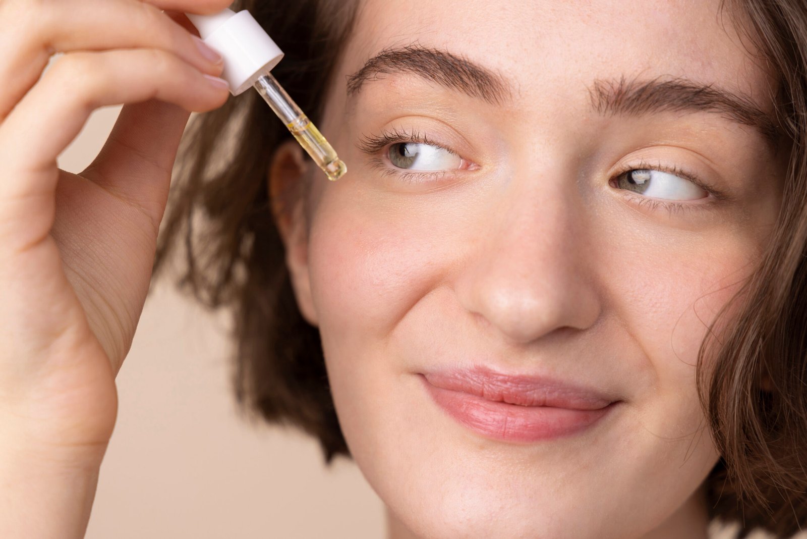 Hyperpigmentation Treatment After Brightening Serums Smiling woman applying a brightening serum before choosing her next hyperpigmentation treatment