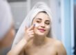 Smiling woman applying a gentle cream as part of hyperpigmentation treatment for sensitive skin