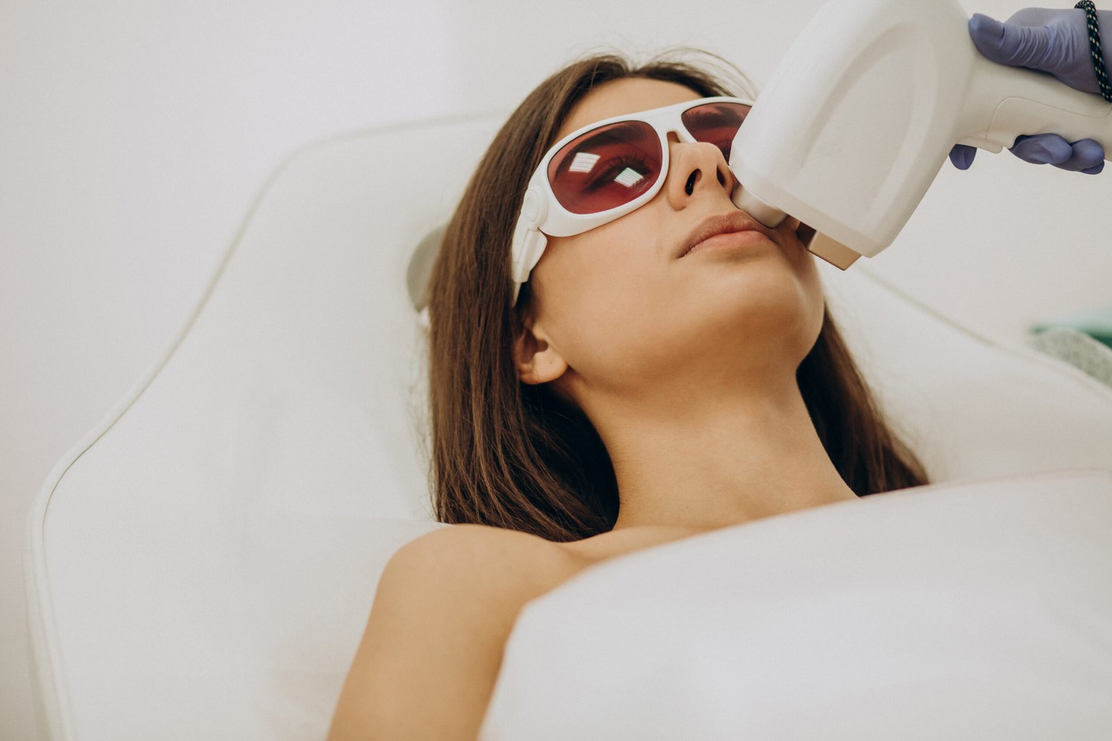 Client in protective eyewear having laser hair removal for upper lip hair