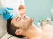 Man with light stubble enjoying a professional facial exfoliation treatment at a med spa