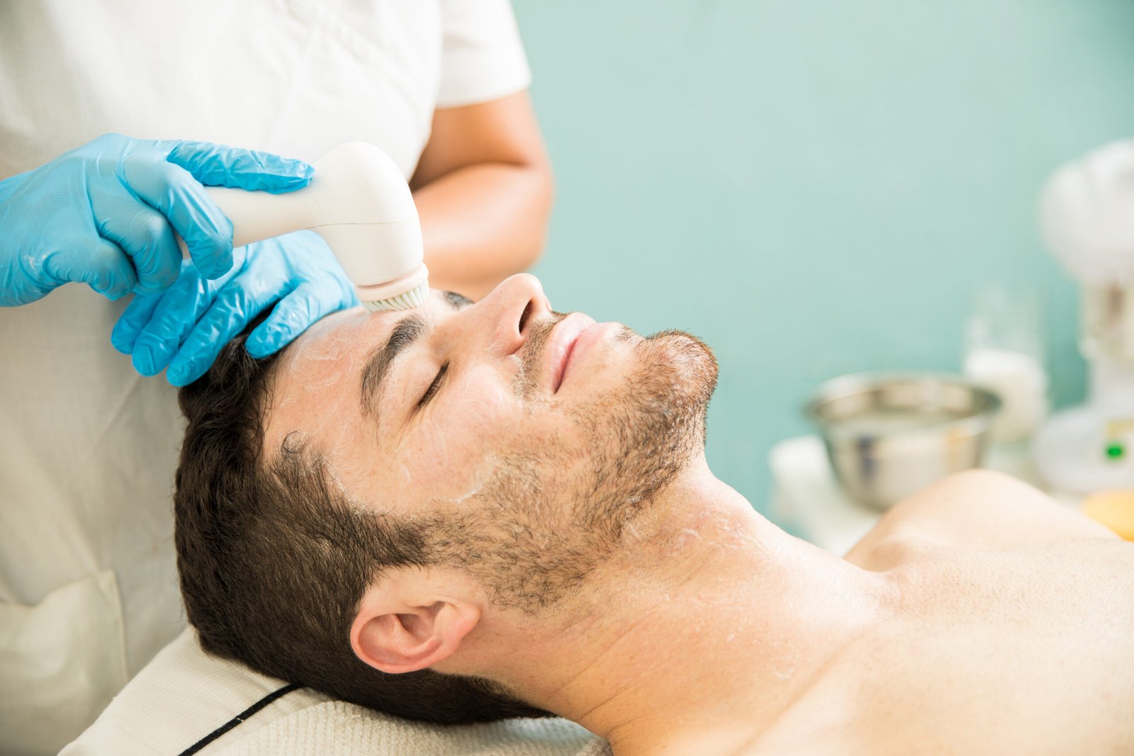 Microdermabrasion for Men With Beards Photo Man with light stubble enjoying a professional facial exfoliation treatment at a med spa