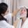 Aesthetician examining a client's skin before a professional dermaplaning appointment