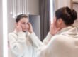 Woman in a med spa checking her cheeks and facial volume in a mirror