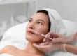 Provider gently injecting the lower cheek beside the mouth to plan Sculptra for hollowing around the mouth